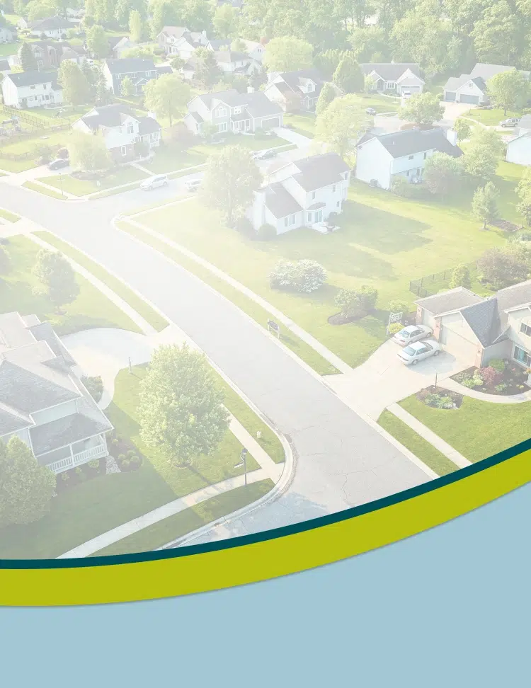 Aerial view of suburban residential neighborhood with single-family homes, tree-lined streets